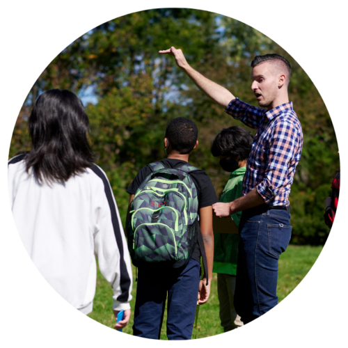 Teacher and students discussing a PLT activity outdoors